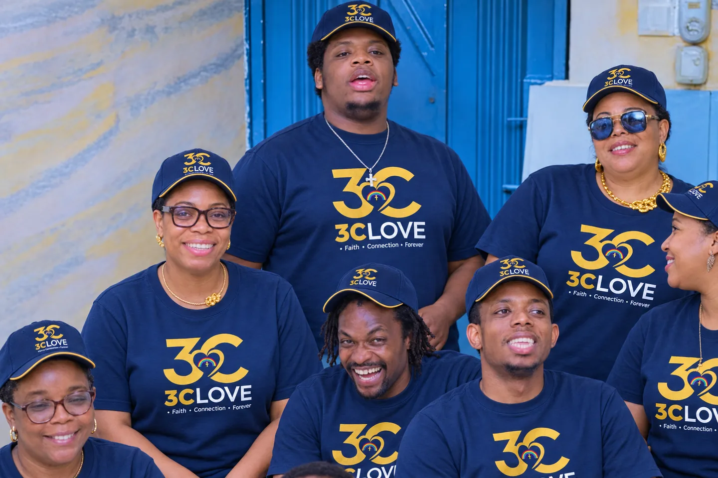 Members of the congregation outside the church in navy 3CLove shirts and caps, laughing together